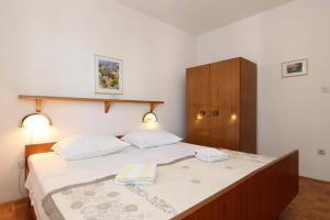 a bedroom with a large bed with two towels on it at Eco-Apartments with nice garden in Baška Voda