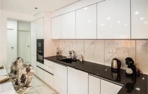 une cuisine avec des armoires blanches et un comptoir noir dans l'établissement Lovely Apartment In Torrevieja, à Torrevieja