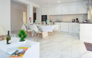 une cuisine avec des placards blancs et une table et des chaises blanches dans l'établissement Lovely Apartment In Torrevieja, à Torrevieja