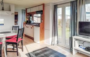 eine Küche und ein Esszimmer mit einem Tisch und einem TV in der Unterkunft Gorgeous Stacaravan In Tzummarum in Tzummarum