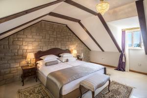 a bedroom with a large bed with a stone wall at Splendida Palace in Split