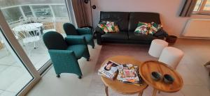 a living room with a couch and chairs and a table at Appartement Bootsman prachtig zicht, groot zonnig terras, garage, fietsenberging OOSTENDE FIETSSTAD - ENSORSTAD in Ostend