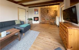 a living room with a couch and a flat screen tv at 3 Bedroom Gorgeous Home In Moddergat in Moddergat