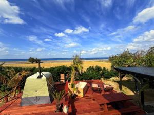 a wooden deck with a view of the ocean at -Serendipity Kikaijima- 海を望む一棟貸切ヴィラ l サウナ&BBQ&シュノーケルセット無料 in Nishime