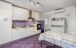 a kitchen with white cabinets and a table in it at Amazing Home In Opatija With Wifi in Opatija