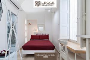 małą sypialnię z czerwonym łóżkiem w białym pokoju w obiekcie InCentro Comfort Suite - Lecce Selection w mieście Lecce