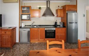 a kitchen with wooden cabinets and a stainless steel refrigerator at Amazing Home In Deltebre With Kitchen in Deltebre