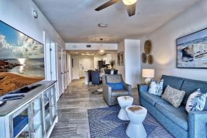 a living room with a blue couch and a table at Oceana 301 East in St Pete Beach
