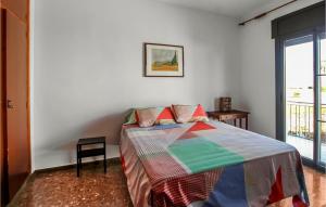 a bedroom with a bed with a colorful quilt on it at Amazing Home In Deltebre With Kitchen in Deltebre +20 photos
