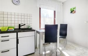 a kitchen with two chairs and a table and a sink at Lovely Home In Roggentin With Wifi in Roggentin +8 photos