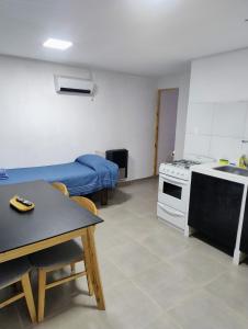 Habitación con cocina, cama y mesa. en Pasaje Del Rey, en El Bolsón