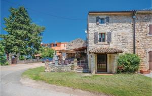 an old stone house with a statue in front of it at 1 Bedroom Amazing Home In Bacva in Bačva