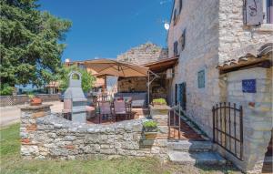 a stone house with a stone wall and an umbrella at 1 Bedroom Amazing Home In Bacva in Bačva