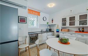 a kitchen with a table and a table and chairs at Stunning Home In Viganj in Viganj