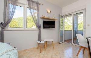 a room with a bed and a table and some windows at 1 Bedroom Awesome Apartment In Klek in Klek