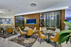 a restaurant with tables and chairs and wine bottles at Hotel 430 in Gaborone