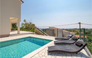 a swimming pool with two lounge chairs and a house at Cozy Home In Mundanije With Wifi in Mundanije +36 photos