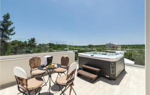 a patio with a hot tub and chairs on a balcony at Nice Home In Krnica With Jacuzzi in Krnica +39 photos