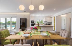 a kitchen and dining room with a wooden table and chairs at Nice Home In Krnica With Jacuzzi in Krnica