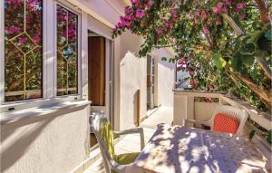 a table and chairs on a balcony with pink flowers at Awesome Apartment In Rab With Wifi in Rab
