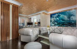 una sala de estar con sillas blancas y una pintura en Nice Home In Crikvenica With Kitchen, en Crikvenica