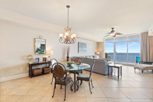 a dining room and living room with a table and chairs at Turquoise Place Condos in Orange Beach