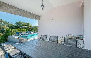 a patio with a wooden table and chairs and a pool at 4 Bedroom Gorgeous Home In Krk in Krk
