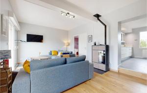 un soggiorno con un divano blu e una cucina di Lovely Home In Saint-Germain-Sur-Ay a Bretteville-sur-Ay
