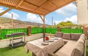 a patio with a table and a grill at 2 Bedroom Lovely Home In Carratraca in Carratraca +8 photos