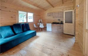 Una sala de estar con un sofá azul y una cocina. en 1 Bedroom Nice Home In Pobierowo, en Pobierowo