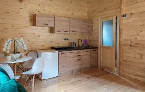 a kitchen with wooden walls and a table at Stunning Home In Pobierowo With Kitchen in Pobierowo