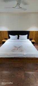 - un grand lit blanc avec un archet dans l'établissement Hotel Centrum, à Siliguri