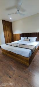 une chambre avec un grand lit avec une tête de lit en bois dans l'établissement Hotel Centrum, à Siliguri