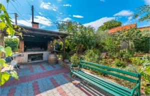 a green bench in a garden with a fireplace at 3 Bedroom Amazing Apartment In Banjevci in Banjevci