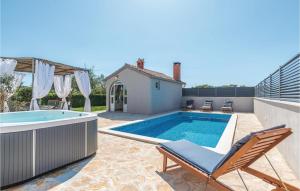 a swimming pool in a backyard with a chair and a swimming pool at 2 Bedroom Gorgeous Home In Zadar in Zadar