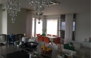 una cucina con tavolo, sedie e finestre di Beautiful Home In Veli Rat With Wifi a Veli Rat
