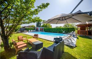 un cortile con piscina con sedie e ombrellone di 3 Bedroom Amazing Home In Fondettes a Fondettes Altre 19 foto
