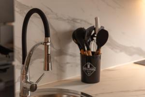 a cup of kitchen utensils is next to a sink at Escapade de Prestige à disneyland & Paris in Torcy +33 photos