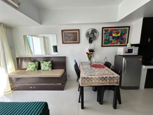 a room with a table and a bed and a table and chairs at Condominium EC Accommodation in Baguio