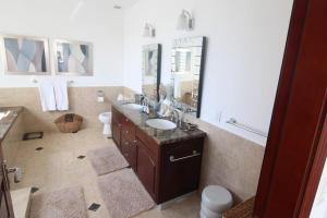 CupecoyにあるCaribbean Bliss Luxury Escapeの洗面台、トイレ、鏡のあるバスルーム