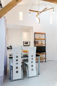 a kitchen with a table and two white chairs at Le Loft in Honfleur