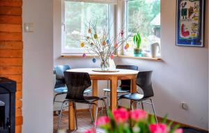 a dining room table with chairs and a vase of flowers at Beautiful Home In Zur With Sauna in Żur