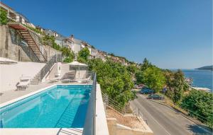 a swimming pool on the side of a building next to the ocean at Holiday Home Plominska Ii in Rabac