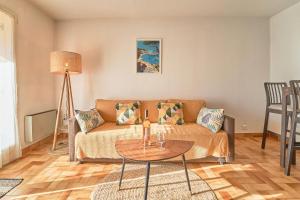 a living room with a couch and a table at Parenthèse ensoleillée - Plage & douceur au Pradet in Le Pradet