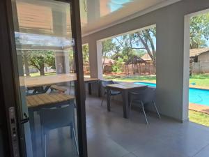 a patio with tables and chairs and a pool at Precious Estates Emerald in Zeerust +9 photos