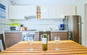 a bottle of wine sitting on a table with two glasses at 1 Bedroom Awesome Apartment In Kustici in Kustići +11 photos