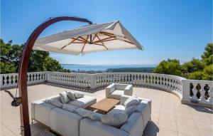 a patio with a white couch and an umbrella at 6 Bedroom Lovely Home In Rab in Rab +38 photos