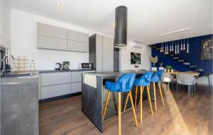 a kitchen with a counter and blue stools in it at Luxurious Home In Dicmo in Dicmo