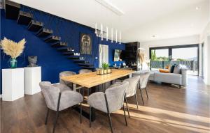 a dining room with a blue wall and a table and chairs at Luxurious Home In Dicmo in Dicmo