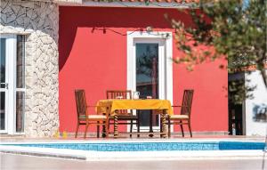 un tavolo giallo e sedie davanti a una casa rossa di Four-Bedroom Holiday Home In Cista Velika a Velika Čista
